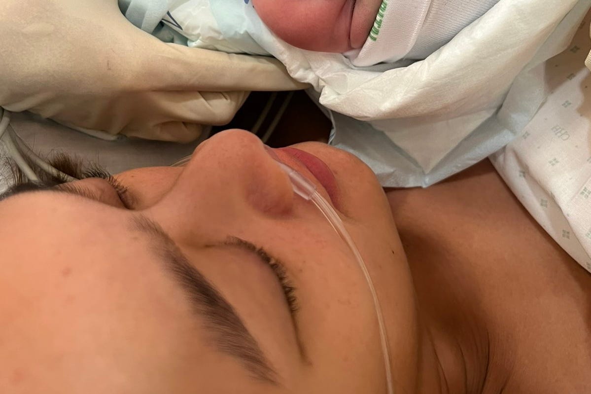 a newborn baby is brought to her mother after delivery
