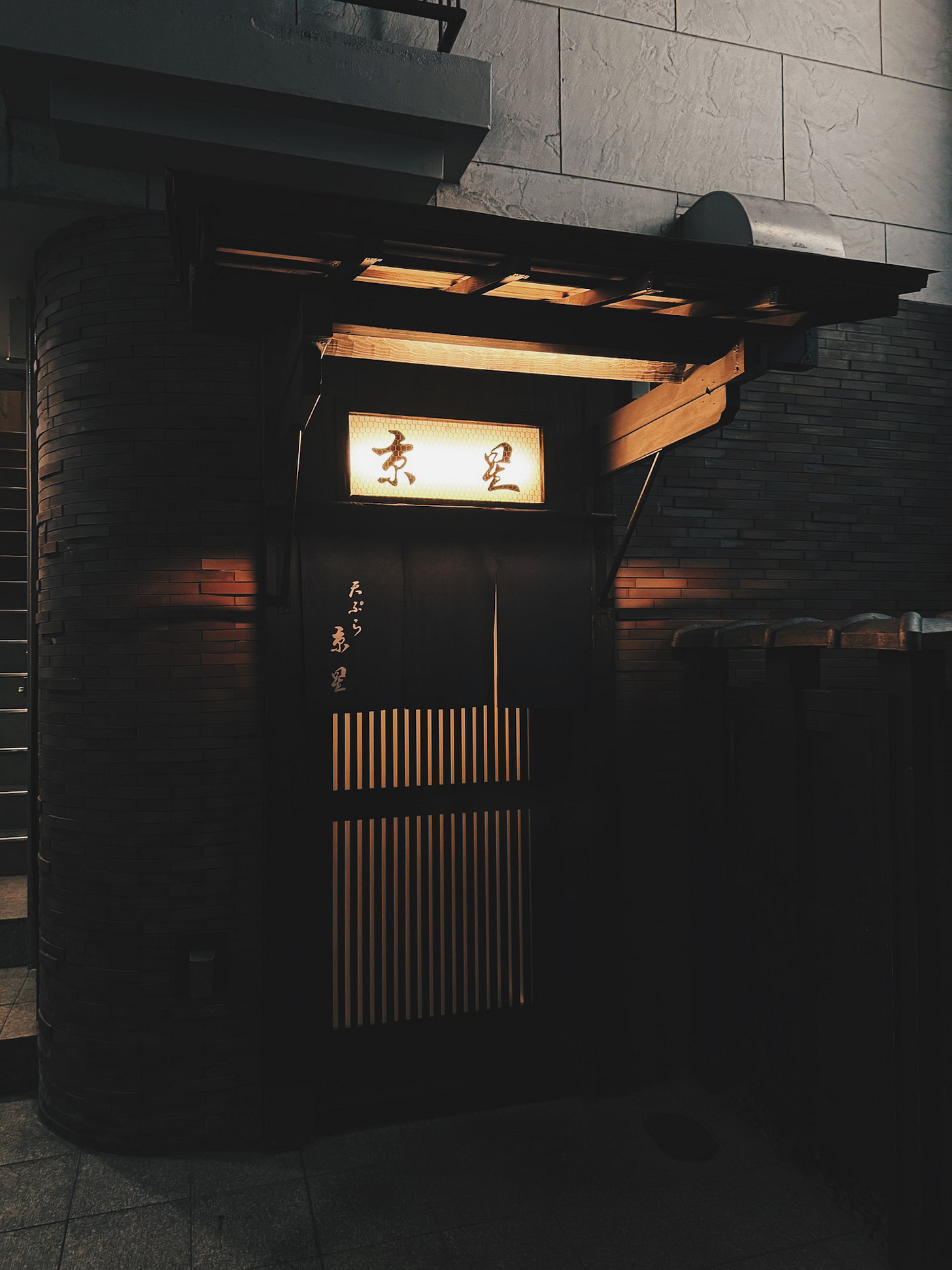 Traditional Japanese Michelin tempura restaurant entrance with wooden sign and lantern lighting in Kyoto at dusk Traditional Japanese Michelin tempura restaurant entrance with wooden sign and lantern lighting in Kyoto at dusk