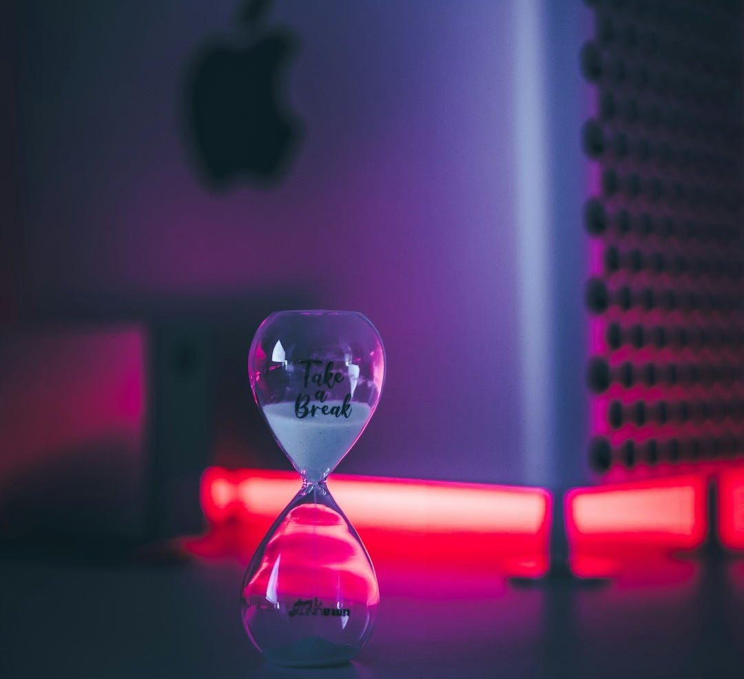 clear glass hour glass with pink light