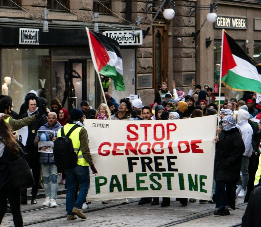 a group of people walking down a street holding flags a group of people walking down a street holding flags