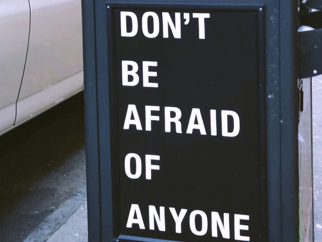 Don't be afraid of anyone sign near vehicle during daytime Don't be afraid of anyone sign near vehicle during daytime