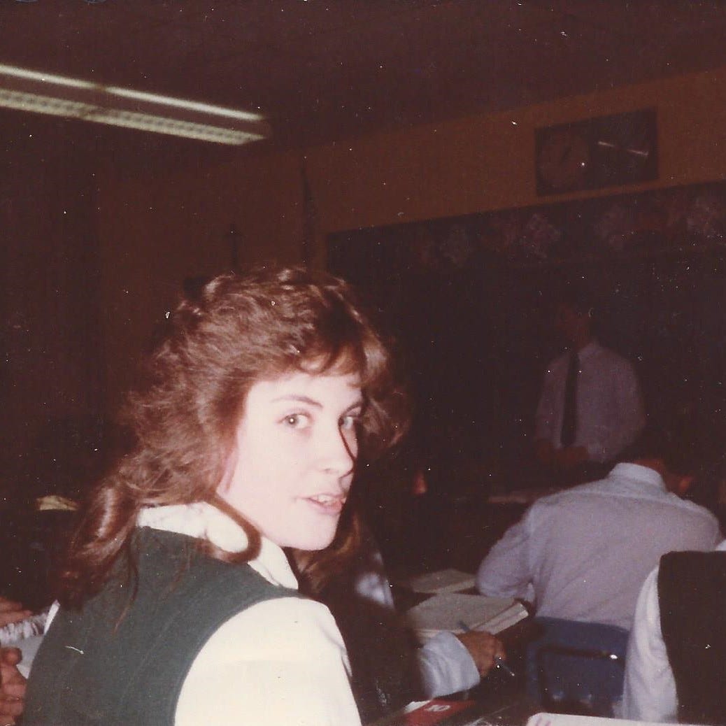 Girl in Catholic school uniform turned around in class instead of listening to the teacher