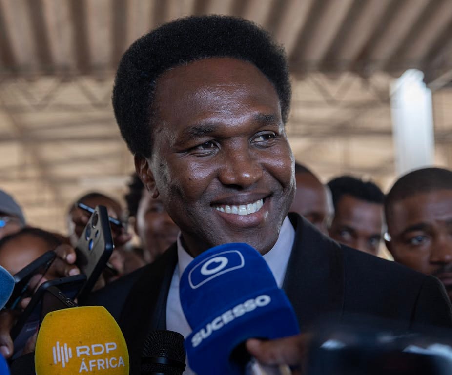 Smiling man with microphones pointed at him