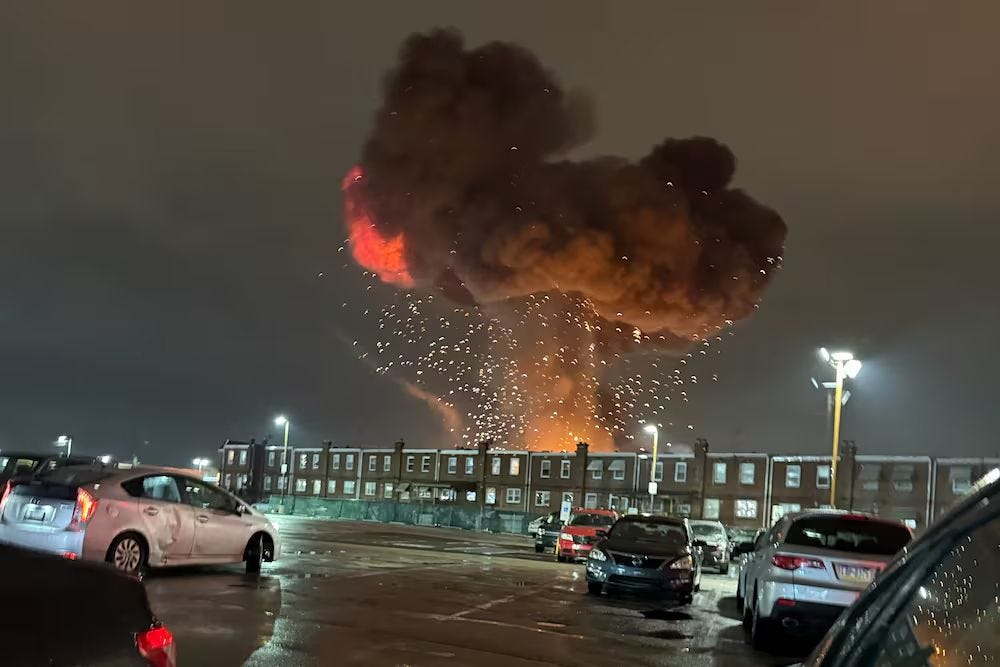 Photo of long row of joined houses with an enormous fireball above it.
