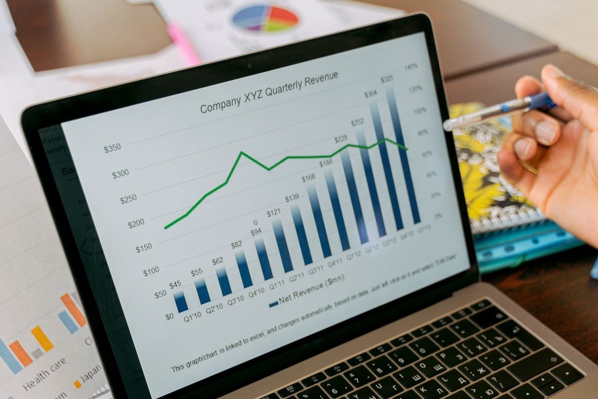 Marketer pointing to a laptop screen displaying predictable quarterly revenue growth charts and data analysis. Marketer pointing to a laptop screen displaying predictable quarterly revenue growth charts and data analysis.
