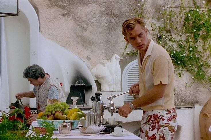 This may contain: two men are preparing food on an outdoor kitchen counter top, while one man is standing in front of the sink