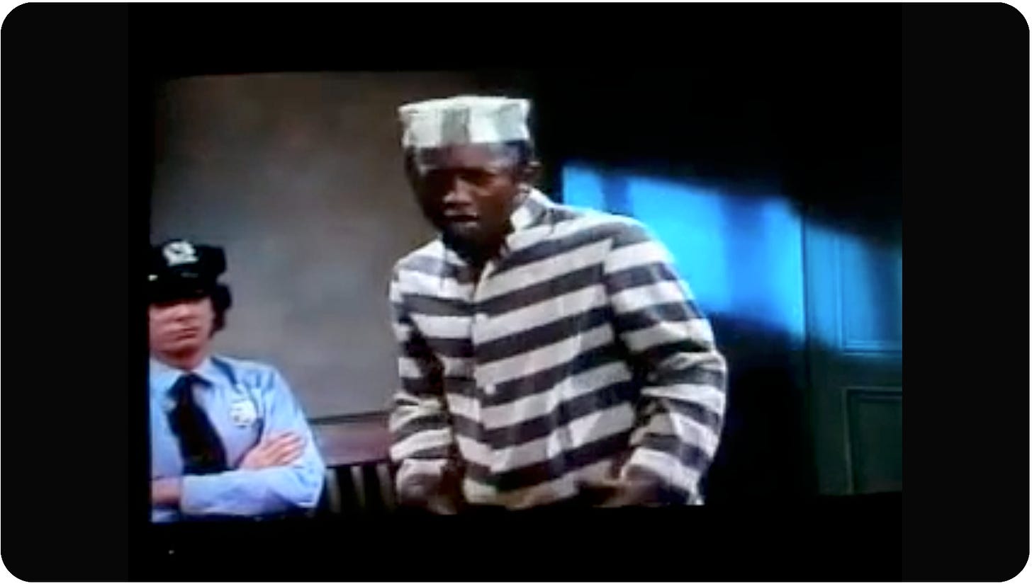 Still video capture of Garrett Morris in cartoonish black and white striped prison garb getting ready to sing.