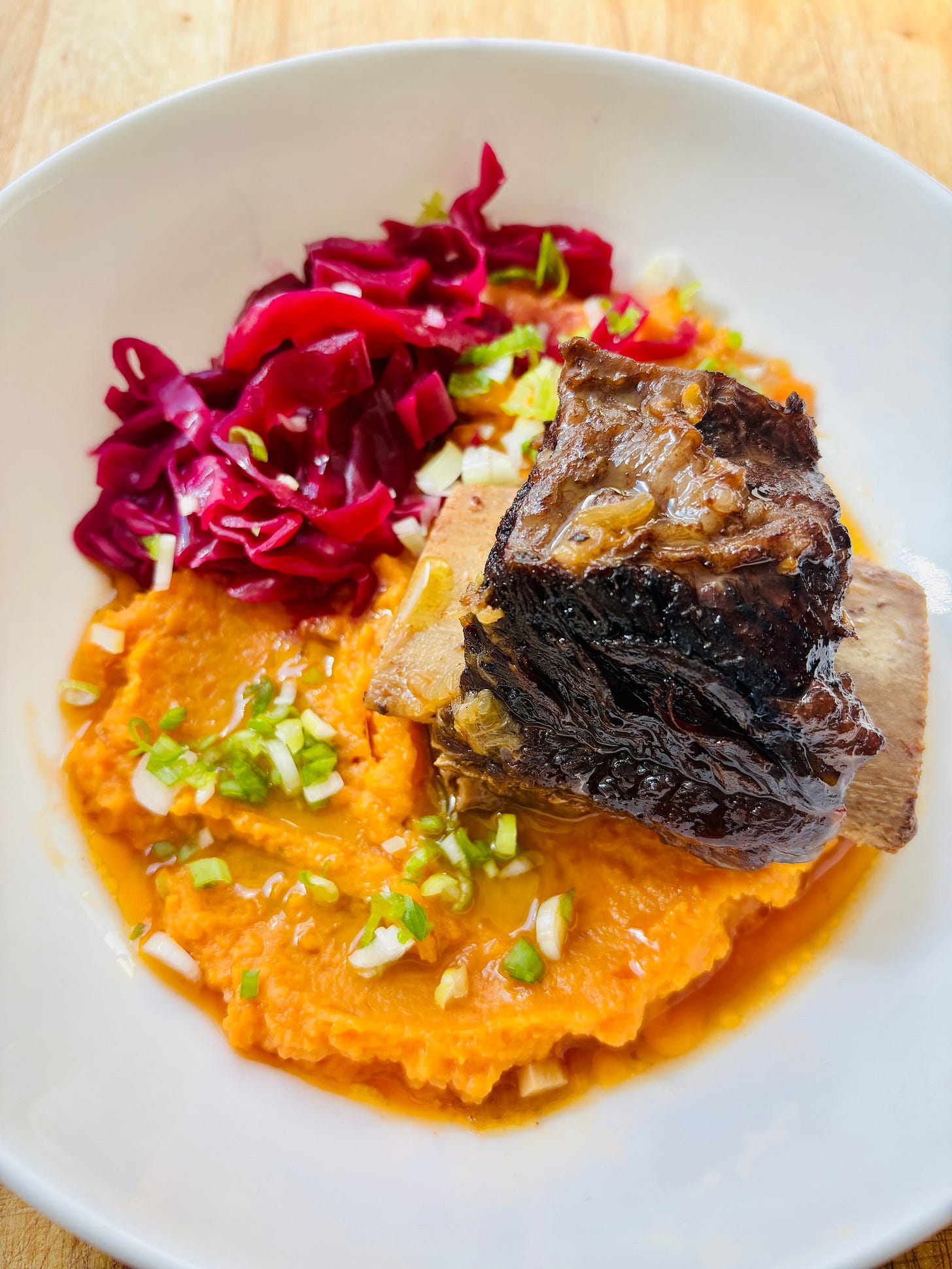 Braised beef short rib on a white plate. Braised beef short rib on a white plate.