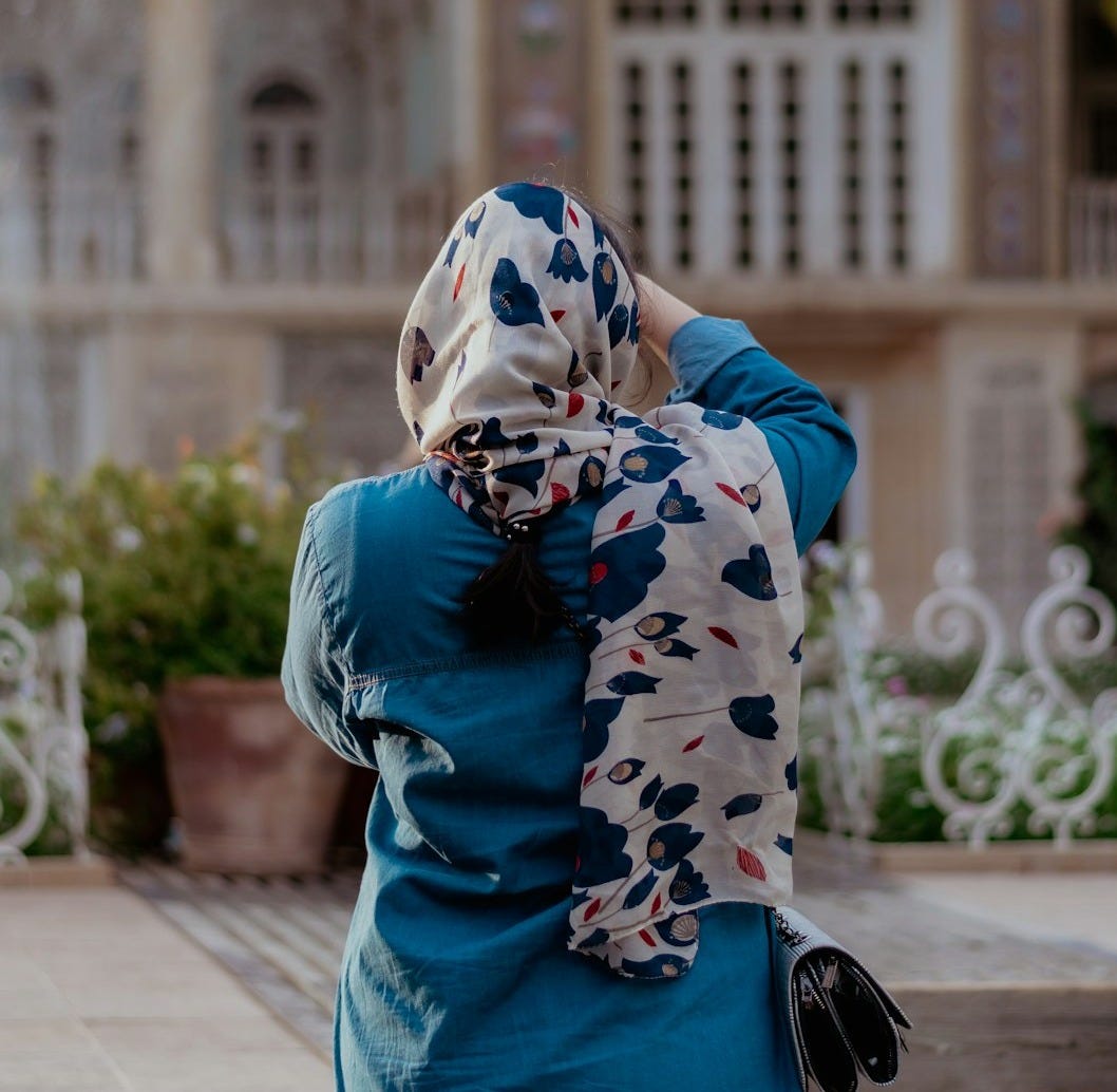 a woman in a blue dress and a white and blue scarf