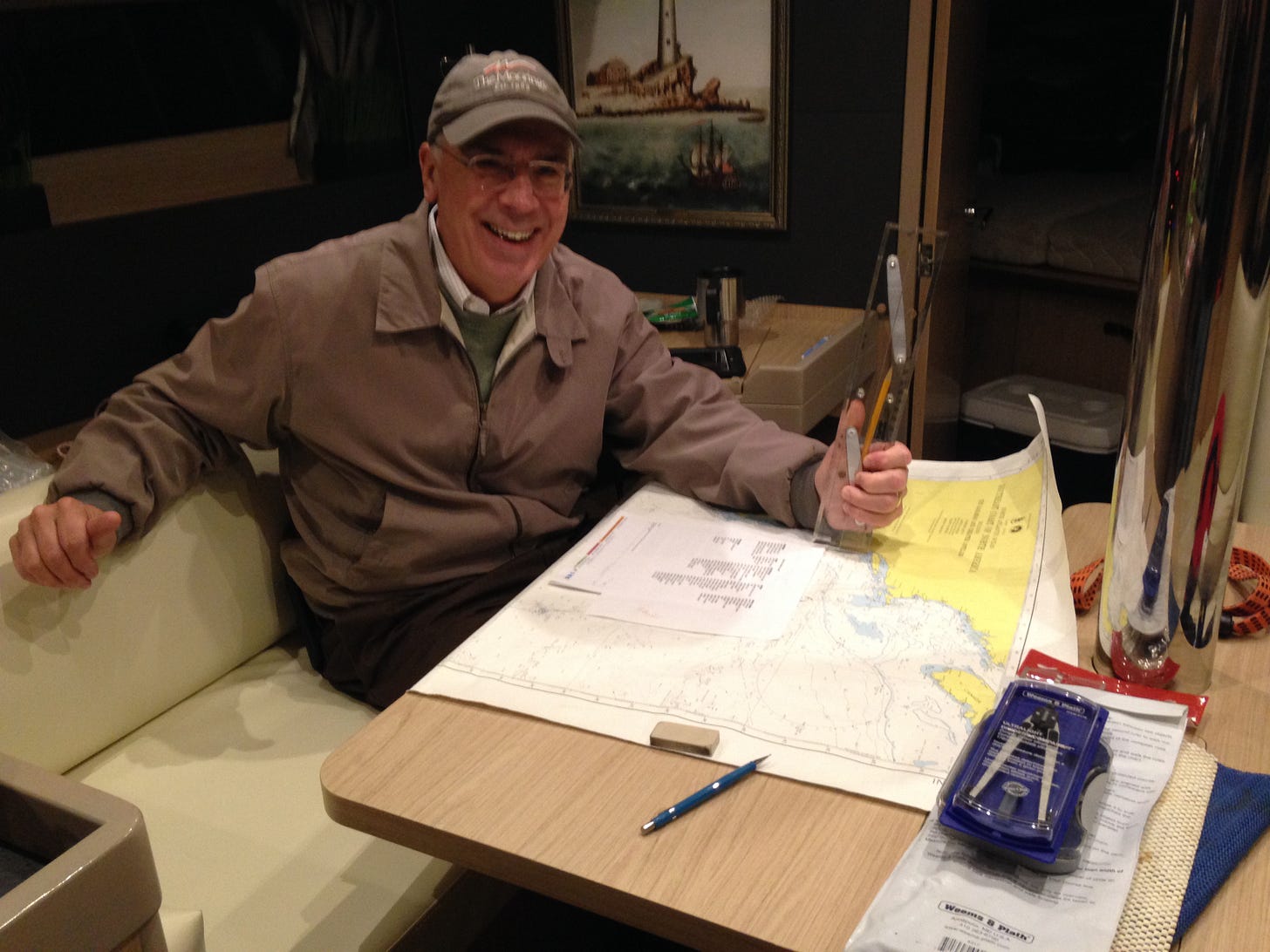 Man at table with nautical maps and navigational tools