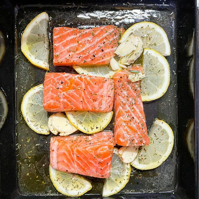 Salmon filets on lemon wedges, ready to be baked. Salmon filets on lemon wedges, ready to be baked.