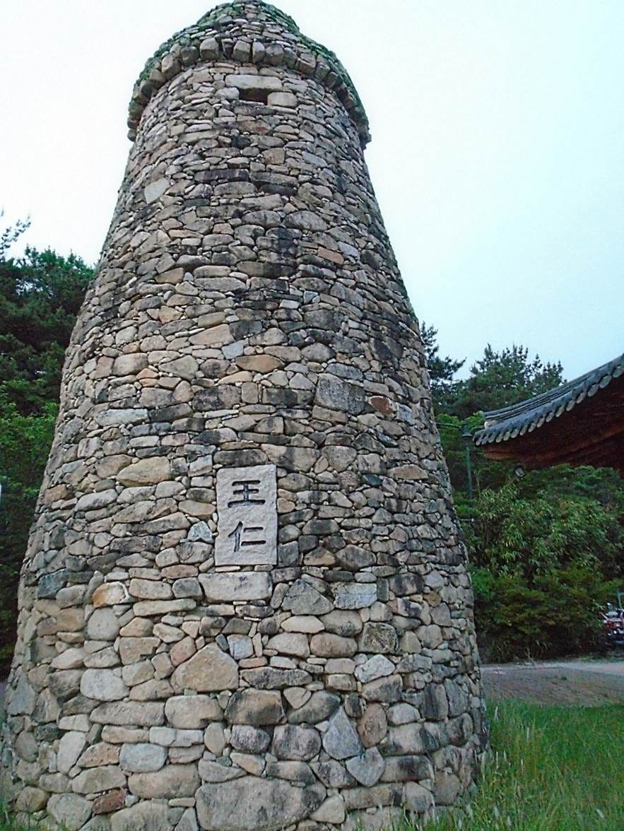 A stone tower with a tower in the middle

AI-generated content may be incorrect.