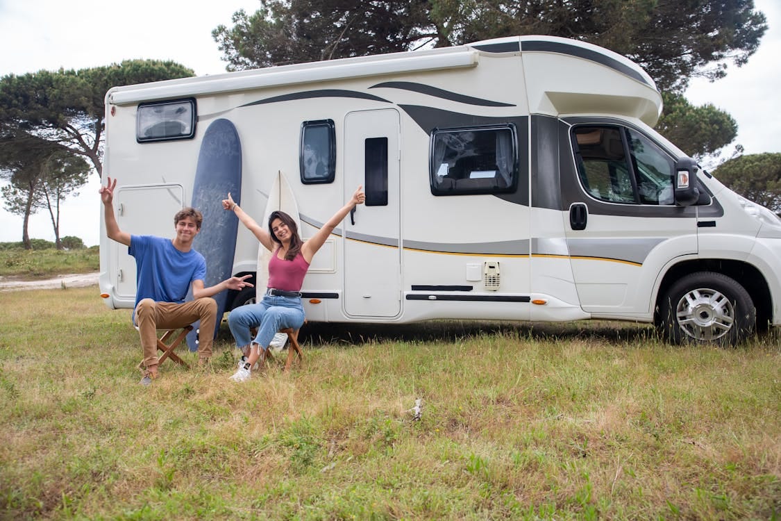 Free Happy couple relaxing by camper van in sunny campsite, Portugal. Stock Photo