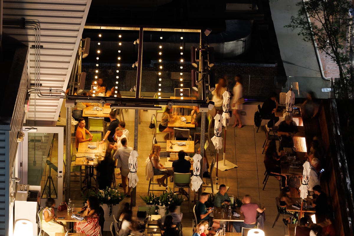 Night rooftop with blurred movement under string lights, signaling urban calm after daytime bird disturbance. Night rooftop with blurred movement under string lights, signaling urban calm after daytime bird disturbance.