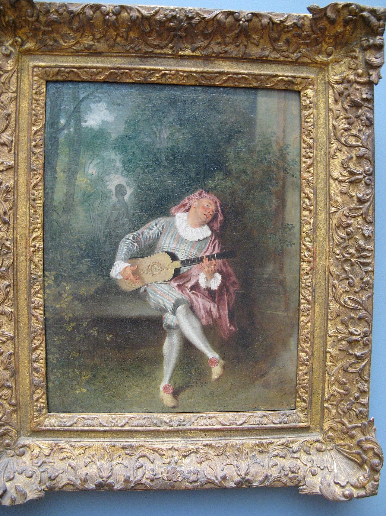 A striped satin comedy figure singing with a guitar A striped satin comedy figure singing with a guitar