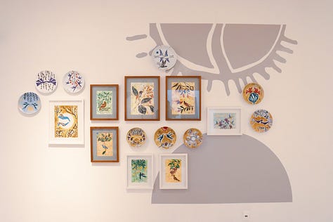 1. Parede do Mauc com obras de Côca Torquato; 2. Porcelana com pintura: ramos marrons na parte debaixo e dois pássaros vermelhos se beijando ao centro; 3. Parede do Mauc com obras de Côca Torquato: à direita, um letreiro grande com a palavra "côca".