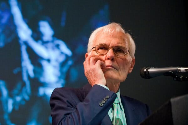 Mr. Jenkins sits and seems to listen, his head resting on his hand, in front of a microphone.