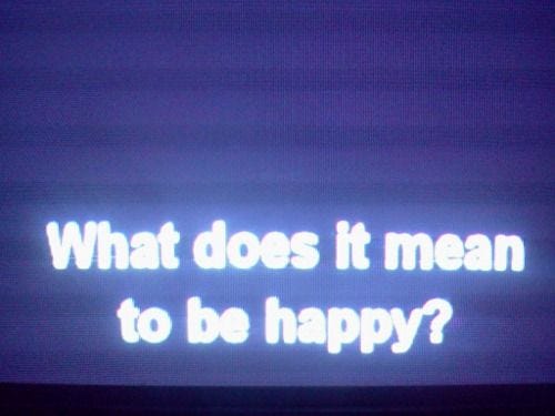This may contain: the words what does it mean to be happy? are projected on a television screen