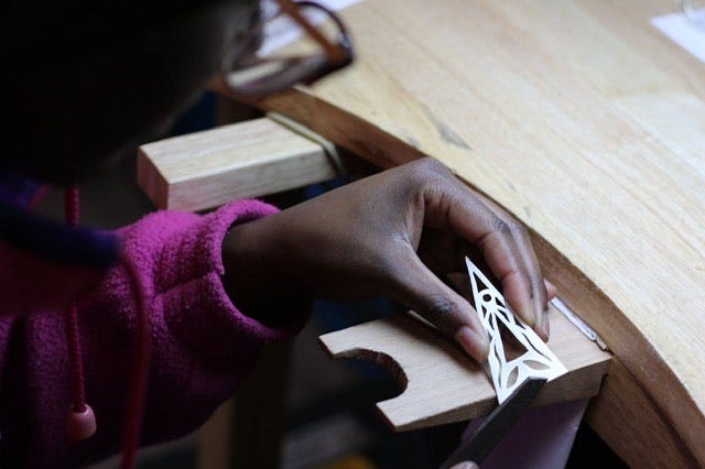 A student at the bench at MasterPeace Academy, an opal, diamond and sapphire brooch by Birmingham-based jeweller Fei Liu.