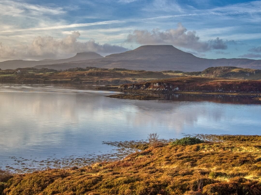 View across a loch with two plateaued hills in the background