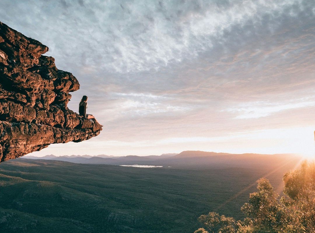 man sitting on mountain rock