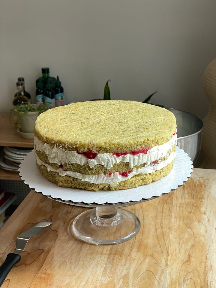 raspberry filling in a cake and next to it, a partially assembled cake