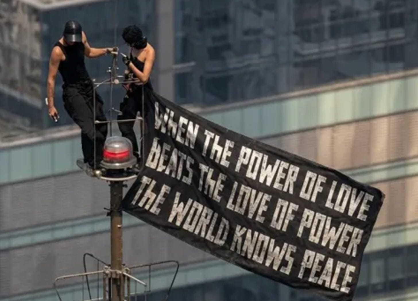 the skywalkers atop the Empire State Building with a flag that reads, "when the power of love beats the love of power the world knows peace" the skywalkers atop the Empire State Building with a flag that reads, "when the power of love beats the love of power the world knows peace"