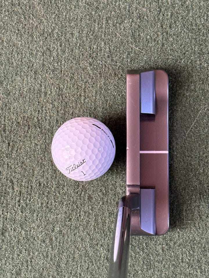 Two Anser style putters at address position with a ball