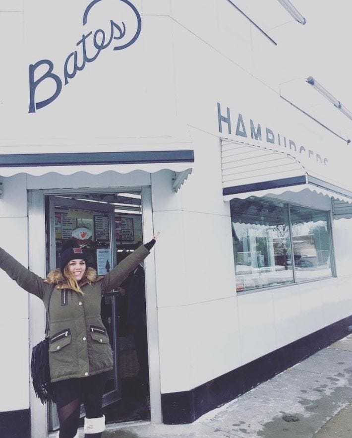 Girl standing in front of Bates Burgers restaurant