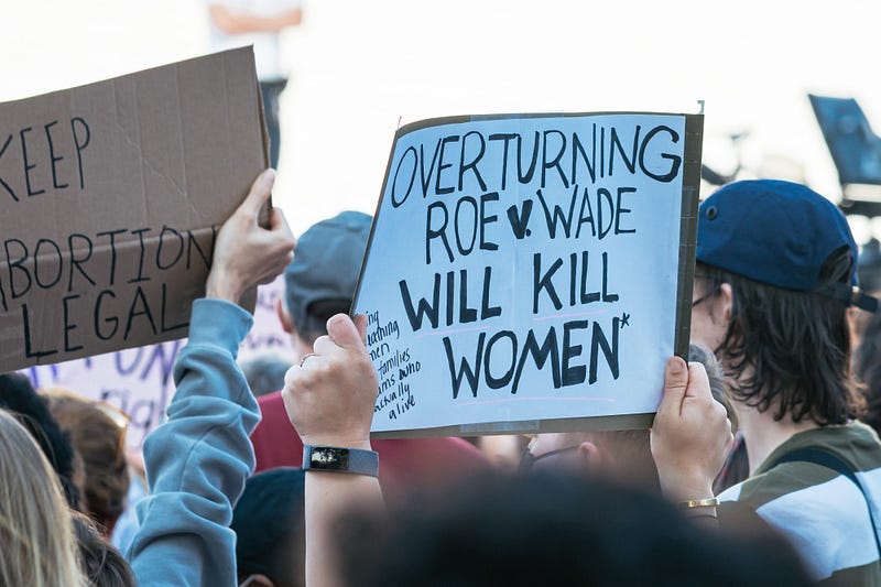 Pro-choice protest signs raised over the heads of demonstrators