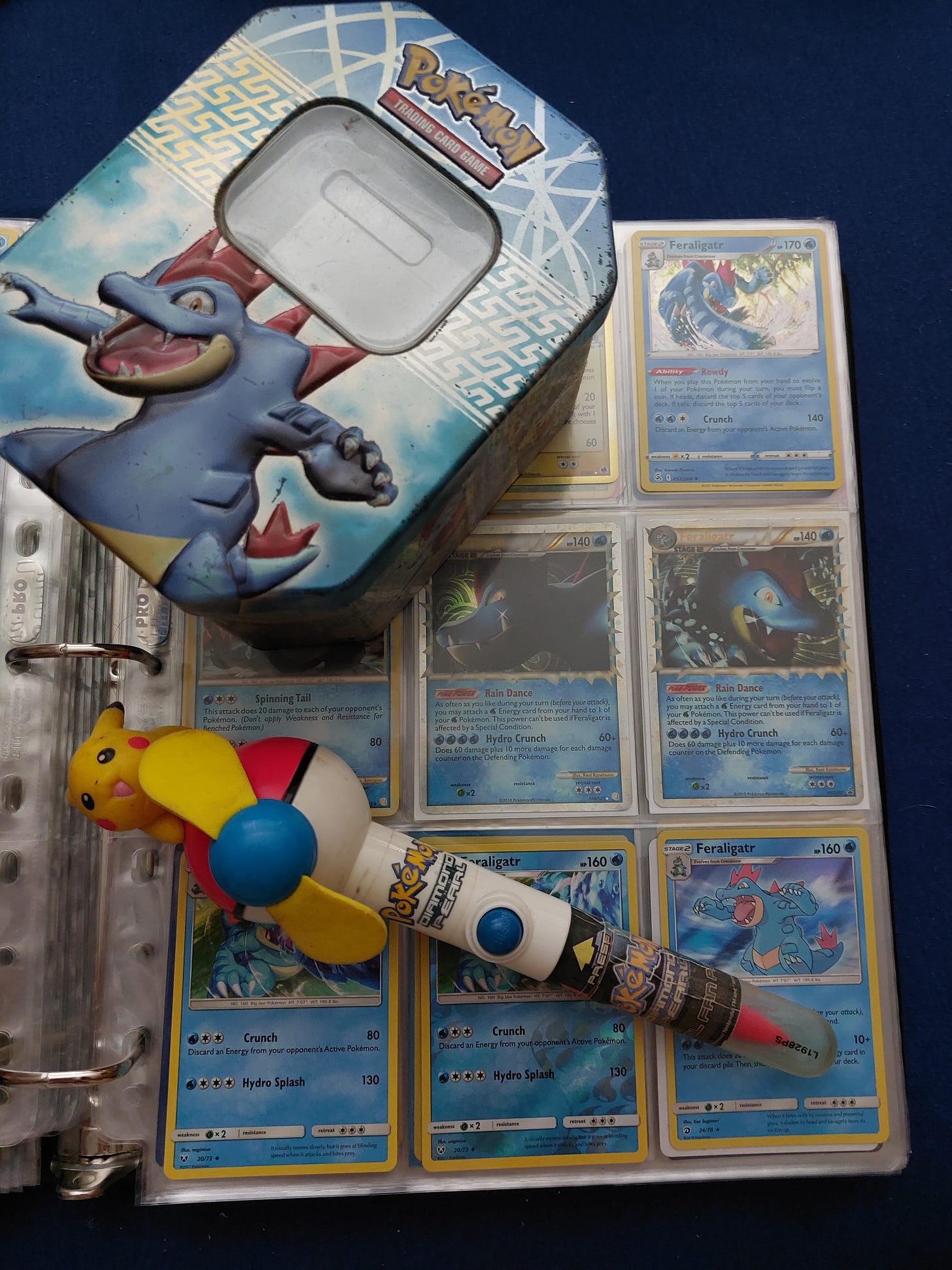 Kimberley is a massive Feraligatr fan! Here are her cards, the Feraligatr tin that started her collection, and the Pikachu propellor pen she has kept hold of from the event Kimberley is a massive Feraligatr fan! Here are her cards, the Feraligatr tin that started her collection, and the Pikachu propellor pen she has kept hold of from the event