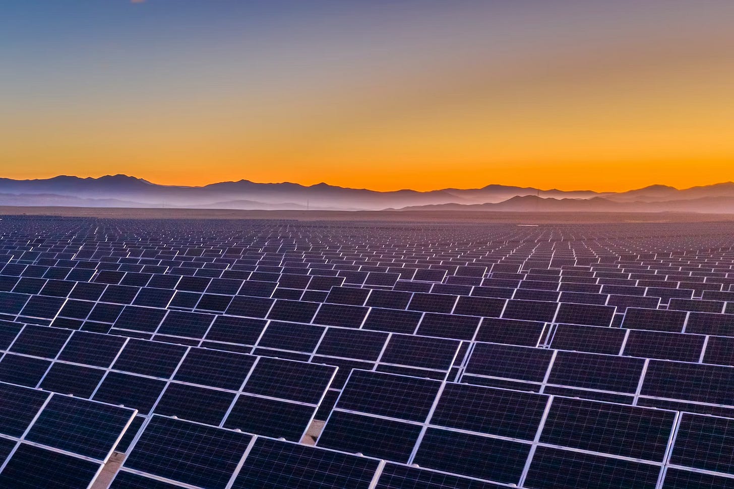 Solar panels in front of sunset. IEA Renewables report title image.
