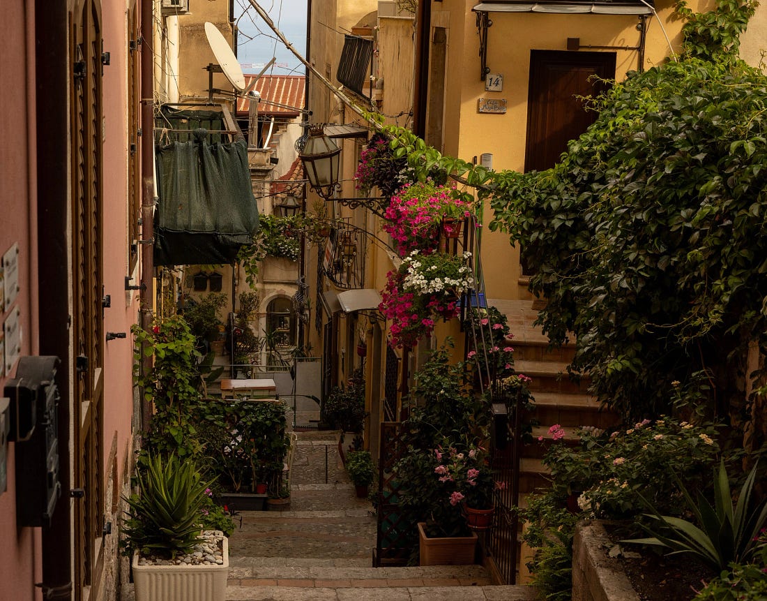 A narrow, flower-filled alley in the old town of Taormina, Sicily. A narrow, flower-filled alley in the old town of Taormina, Sicily.