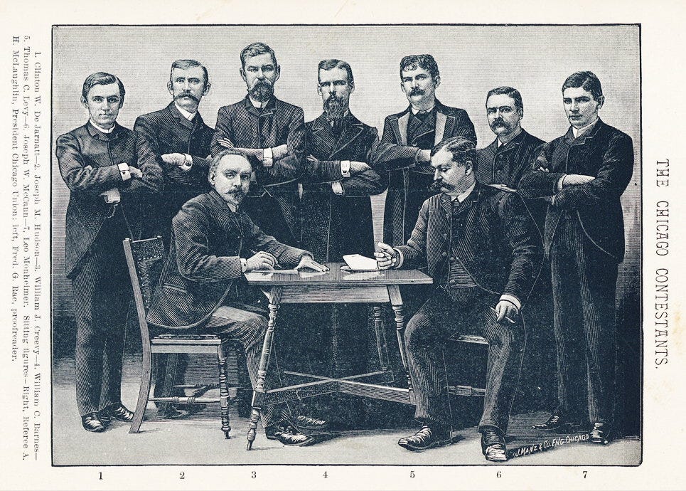 Nine men in dark suits arranged around a wooden table, two seated and seven standing behind with arms crossed, captioned 'The Chicago Contestants.'