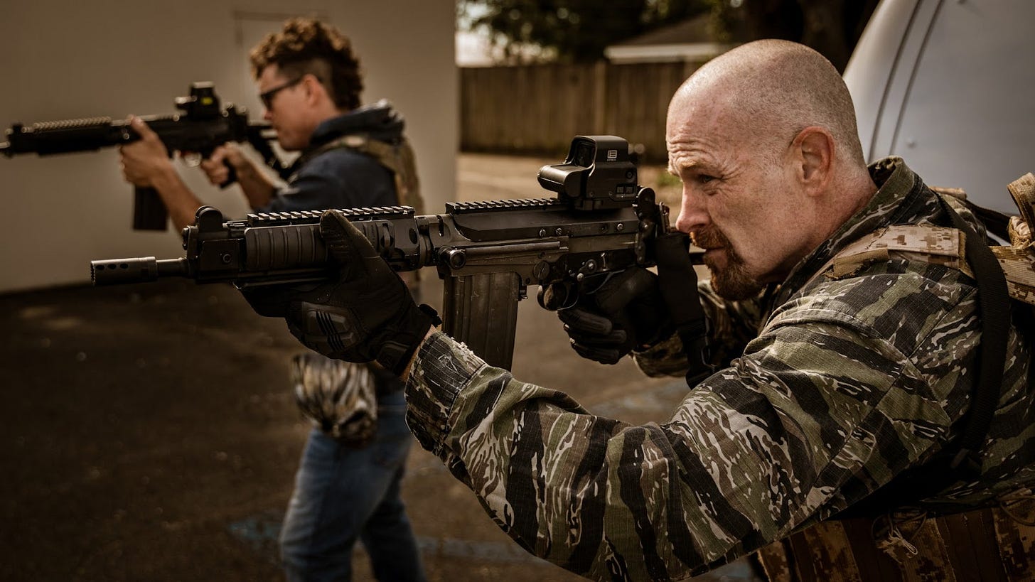 Max Martini and another man wear tactical vests and aim down the barrels of their rifles in The Channel