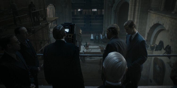 Coronation committee members gaze through a TV camera at Westminster Abbey during preparations for the ceremony. Meanwhile we look at them through the gaze of a camera that was pointed at them on set.