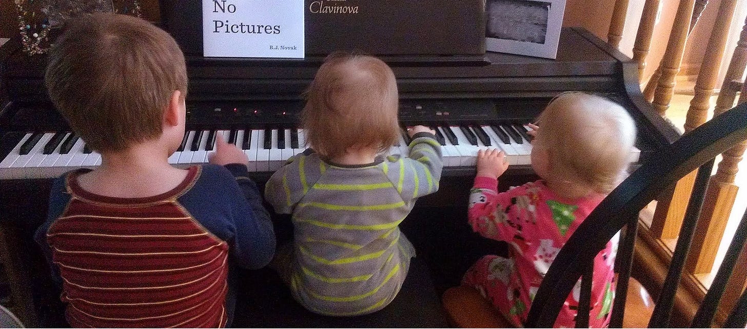 Three young kids at the piano