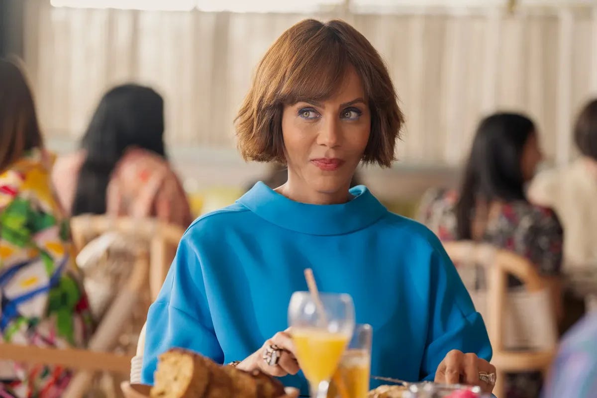 The character Lisa Todd Wexley looking cunty at brunch in a blue sweater.
