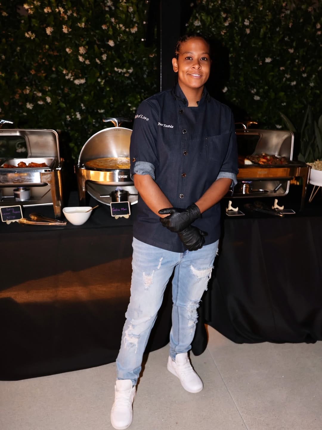 Chef in black coat standing in front of a silver buffet station