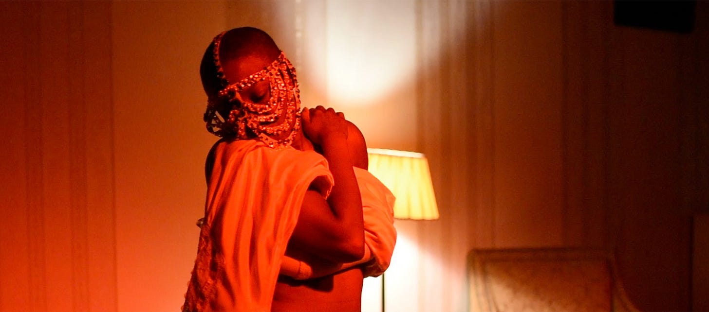 Μια εικόνα της Jennifer Hagre να στέκεται σε ένα σκοτεινό δωμάτιο μπροστά από μια λάμπα. Η Τζένιφερ κρατά ένα σεντόνι στα χέρια τους και κοιτάζει κάτω και δεξιά.