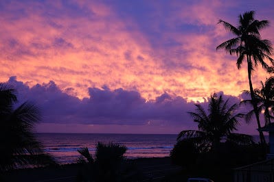 A sunset with purple clouds and water