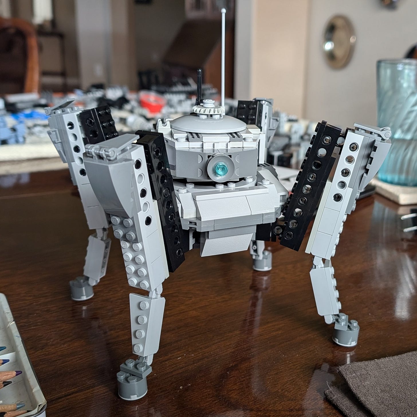 A Lancer mech I made out of Lego. It's the spiderlike SSC Swallowtail in gray-black coloration with a piercing single blue eye and a long dorky antenna.