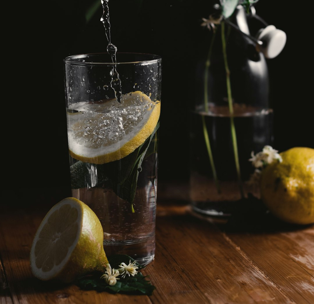 clear drinking glass beside flower vase
