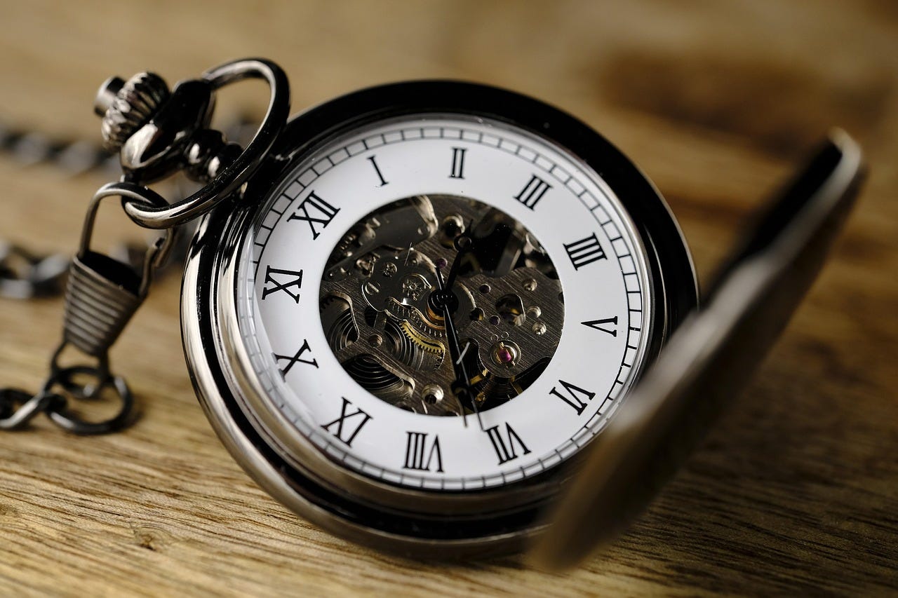a traditional ornate pocket watch, open and lying on a wooden surface a traditional ornate pocket watch, open and lying on a wooden surface
