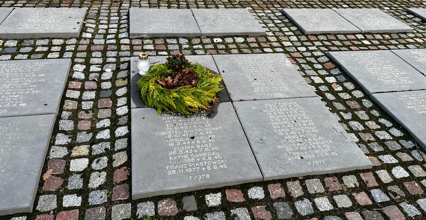 cobblestone yard set with concrete slabs inscribed with lists of names