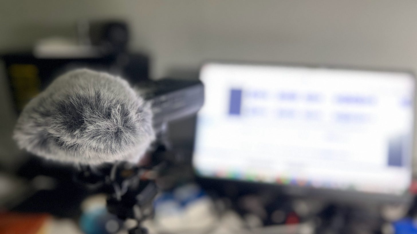 Image of a microphone and compter displaying audio recording software