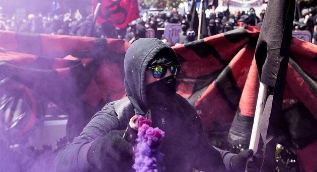 A person in a black hoodie holding smoke bombs

AI-generated content may be incorrect.