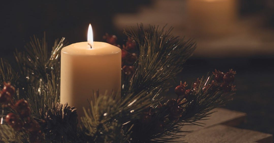 white pillar candle on brown wooden table