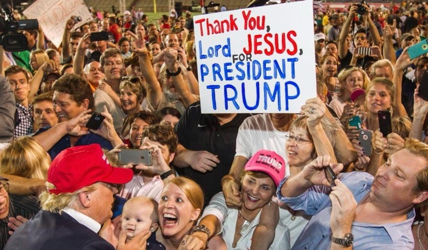 A crowd of people holding a sign

Description automatically generated