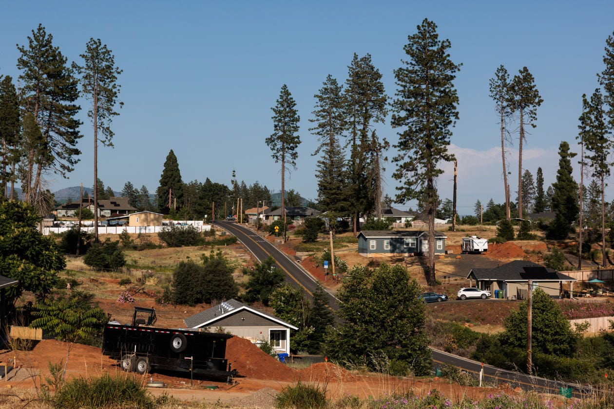 New homes and houses under construction in a wildfire-recovering landscape.